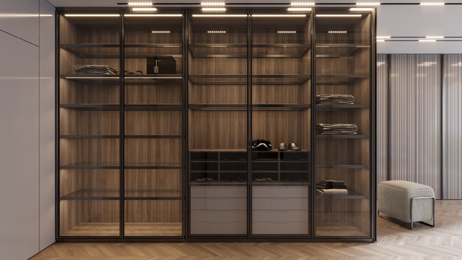 Glazed wardrobe fronts revealing warmly lit shelves, rails and drawers